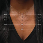 Necklace with diamond pendants on a person wearing a black top, showing size measurements.