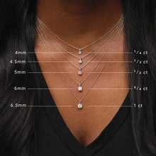 Necklace with diamond pendants on a person wearing a black top, showing size measurements.